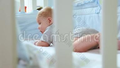 一个小孩在<strong>婴儿床</strong>上的特写镜头，笑着从<strong>婴儿床</strong>的格子间侧视。 快乐的童年，幼稚的快乐
